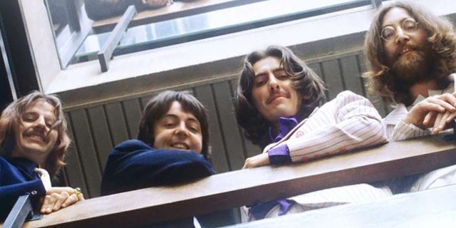 Die Beatles schauen über ein Geländer herunter