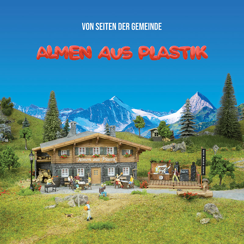 Albumcover von "Almen aus Plastik" der Gruppe Von Seiten der Gemeinde. Darauf zu sehen ist eine Miniaturalm aus Plastik