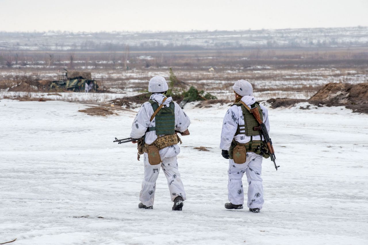 Ukrainian Military Forces servicemen walk in a field during live-fire exercises near the town of Chuguev, Kharkiv region on February 10, 2022