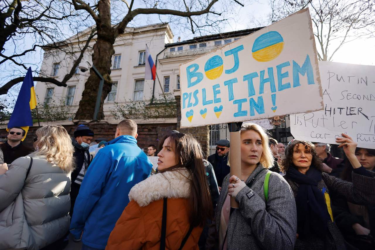 Demonstrators hold placards at a protest rally outside of the Russian Embassy in London, on February 26, 2022 following Russia's invasion of Ukraine.