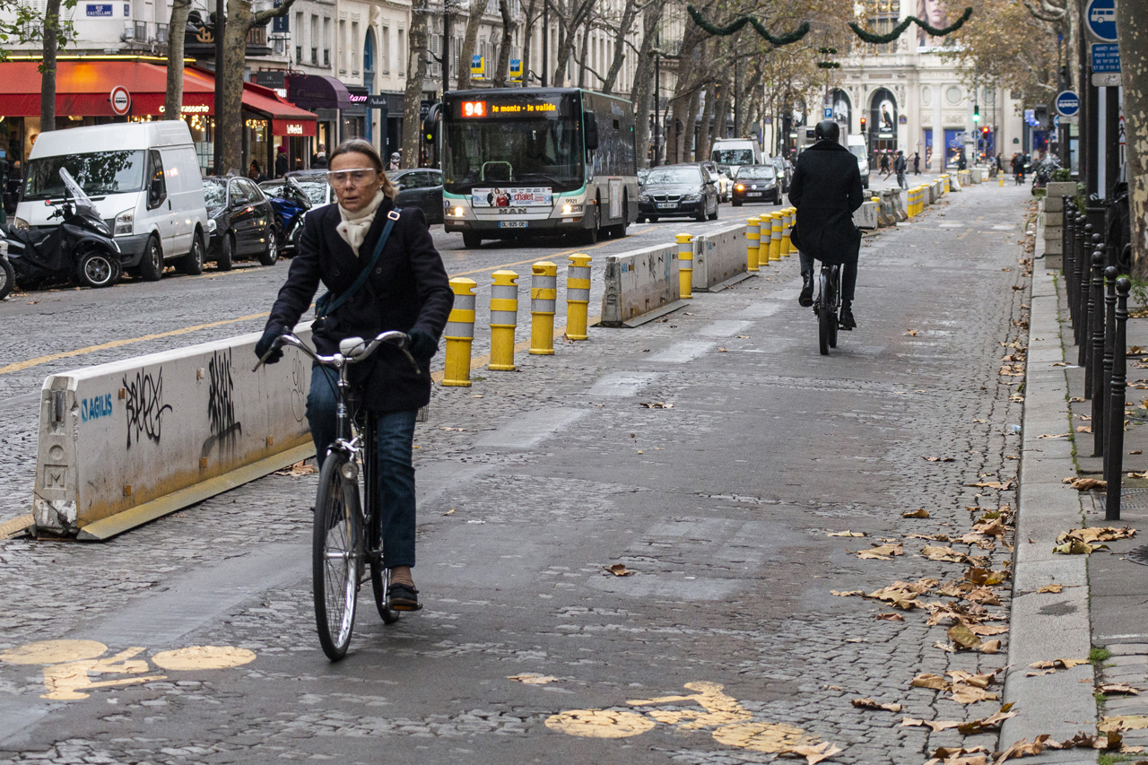 Two cyclists riding on a 'coronapiste', a temporary cycling road, on the 'Rue Tronchet' in Paris on November 16, 2021. Most of these temporary routes are supposed to become permanent.