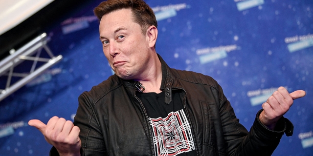 Elon Musk posiert und hält beide Daumen waagrecht