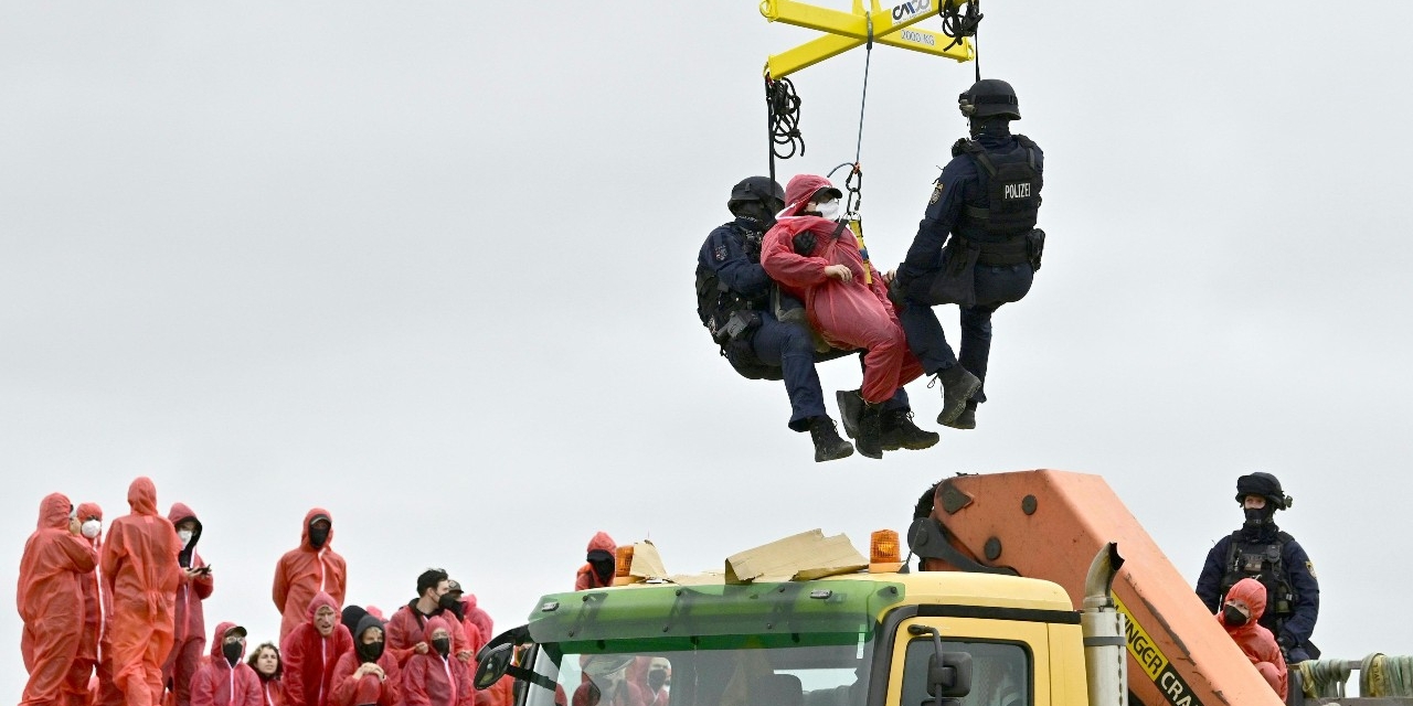 Aktivistinnen werden mit einem Kran der Polizei vom Baucontainer gehoben