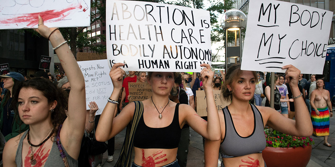 Abtreibungsaktivistinnen demonstrieren gegen die Entscheidung des US-Höchstgerichts mit Schildern und blutigen Händen auf ihren Bäuchen