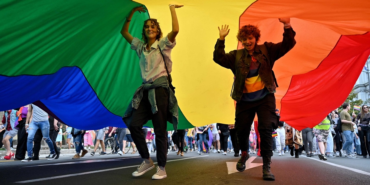 EuroPride Belgrad 2021, zwei Menschen unter einer Regenbogenflagge