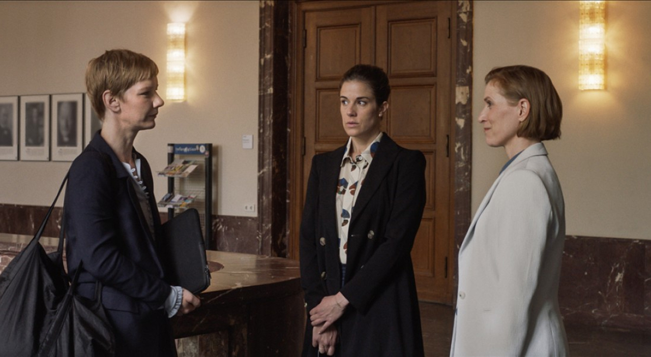 Sandra Hüller, Anne Schäfer und Judith Hofmann im Film "Alle reden übers Wetter" von Annika Pinske in einer Szene, die an einer Uni spielt.