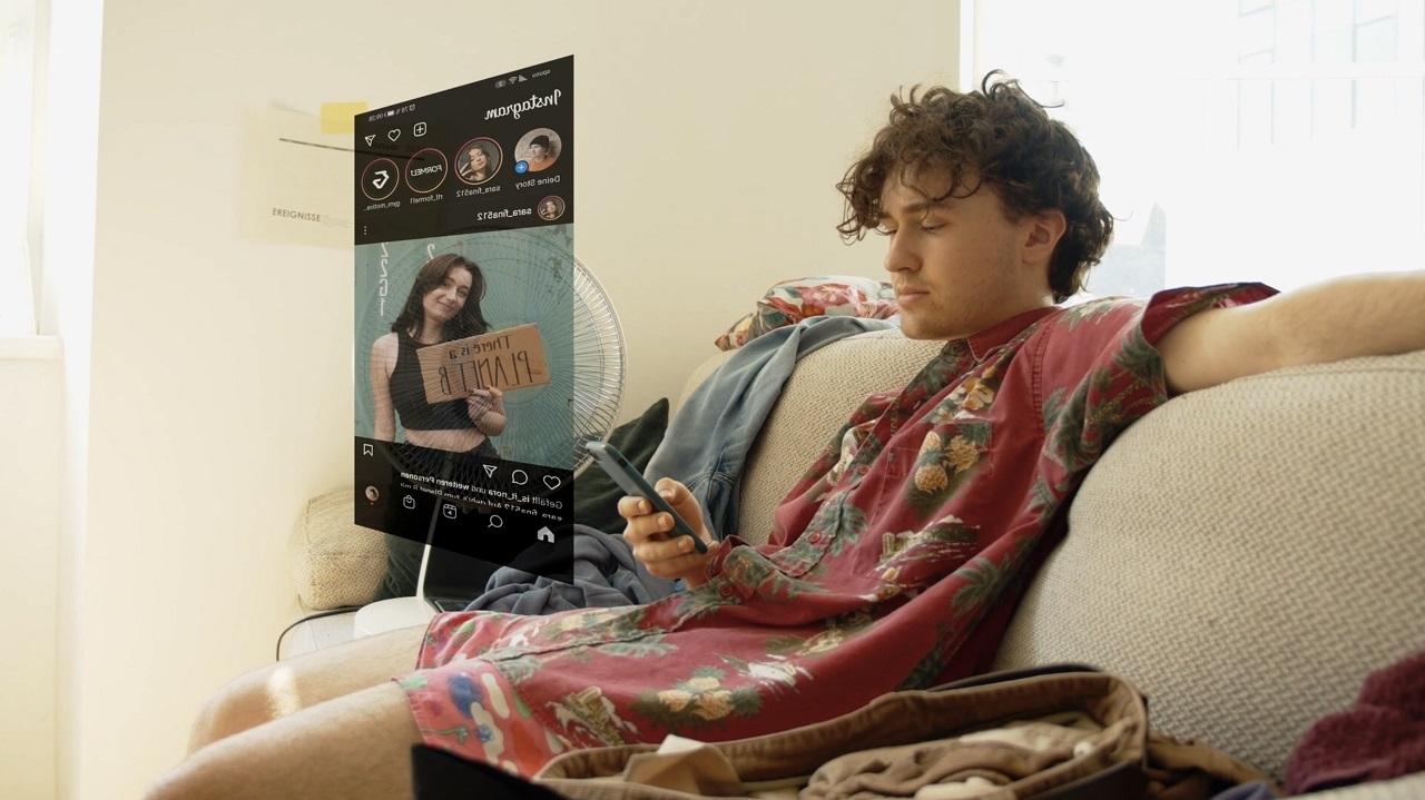 Bursch auf Couch schaut sich ein Video am Smartphone an. Szene aus dem österreichischen Kurzfilm "Nebulose".