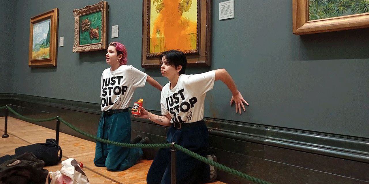 A handout picture from the Just Stop Oil climate campaign group shows activists with their hands glued to the wall under Vincent van Gogh's "Sunflowers".