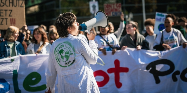 Eine Fridays for Future Aktivistin ruft durch ein Megafon, Klimastreik im September 2022 in Wien