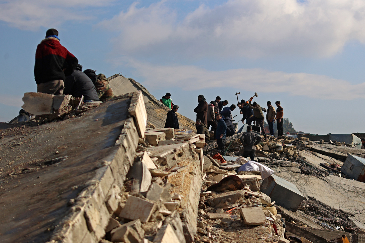 Eingestürzte Gebäude in Jindayris, nach den Erdbeben in der Türkei und in Syrien. Menschen versuchen, andere unter den Trümmern zu finden.
