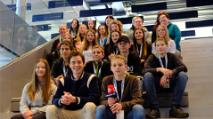 Ö3-Moderator Philipp Hansa sitzt mit Schülerinnen und Schülern der MS Windischgarsten auf der Ö3-Eventtreppe