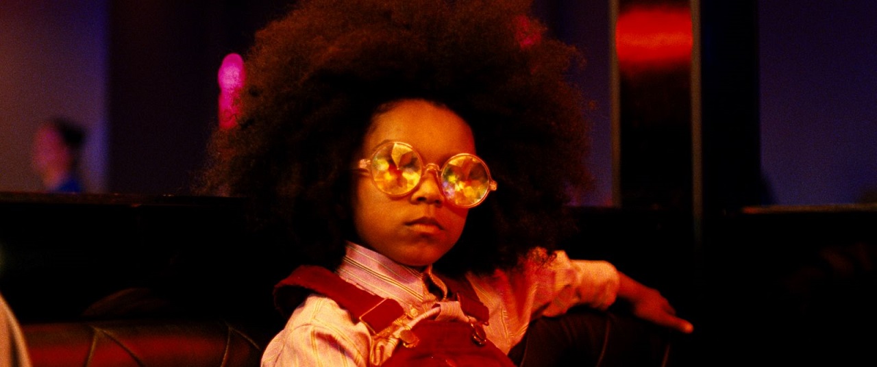 Kind mit Afro und Sonnenbrille.