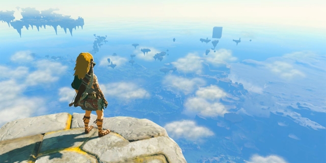 Screenshot aus "Tears of the Kingdom". Link steht am Felsrand und blickt in die Ferne auf Himmelsinseln