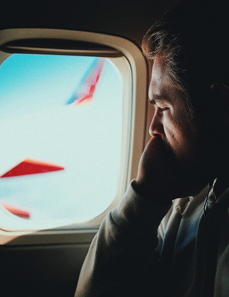 Ein Mann im Flugzeug schaut aus dem Fenster raus