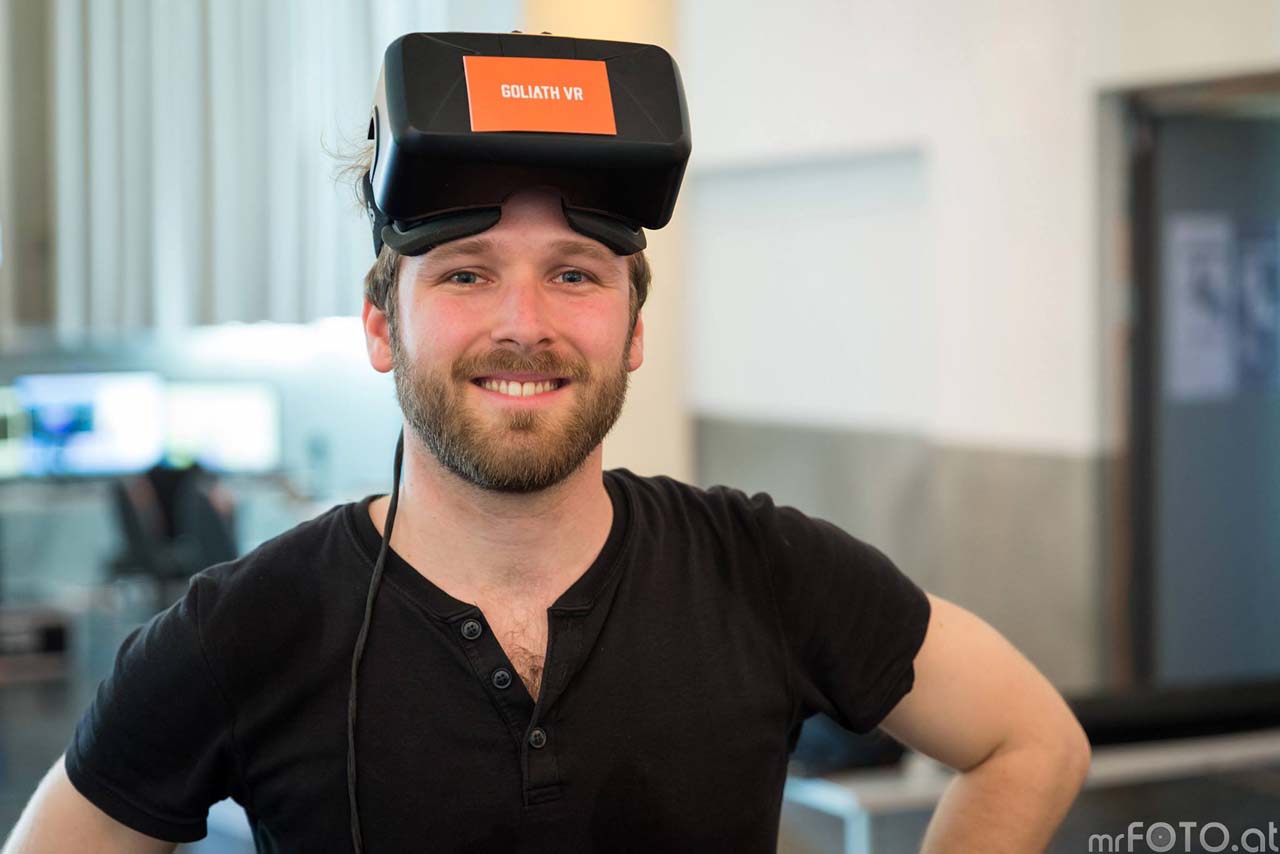 Wolfgang Tschauko mit einem hochgeschobenen VR-Headset am Kopf.