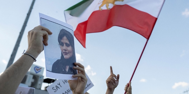 Bild von Jina Mahsa Amini und wehende Iran-Flagge bei einer Demo