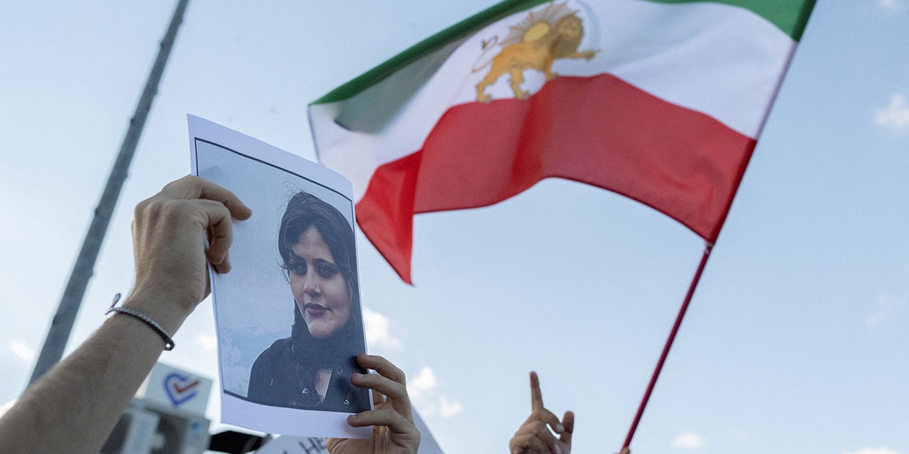 Bild von Jina Mahsa Amini und wehende Iran-Flagge bei einer Demo