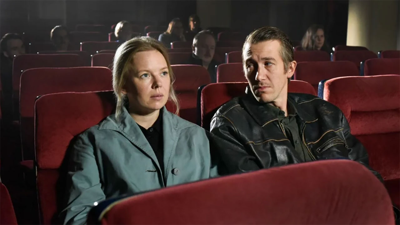 Szene aus "Fallende Blätter": Mann und Frau sitzen nebeneinander im Kino