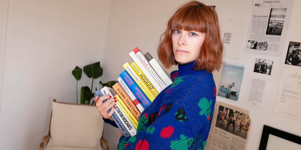Anna Miller mit einem Haufen Bücher im Arm