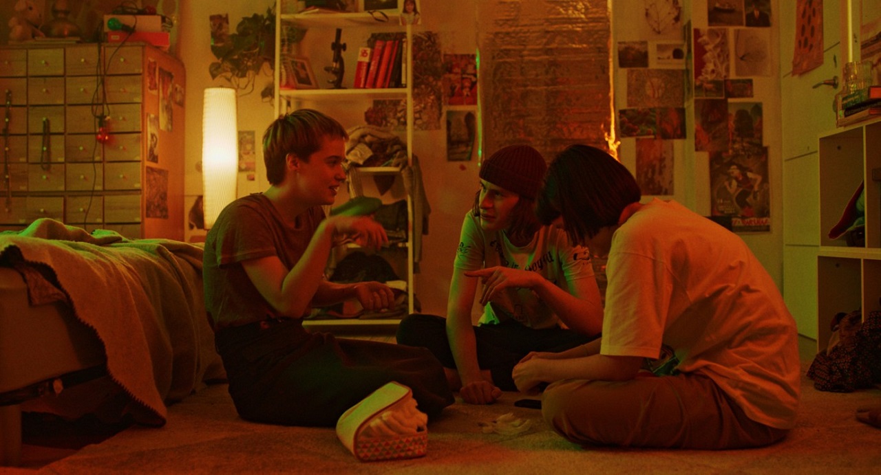 "Stop Zemlia": Drei Teenager sitzen in einem Jugendzimmer und plaudern.
