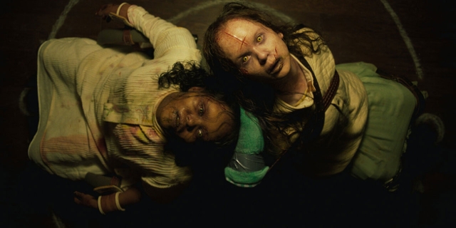 Szene aus The Exorcist: Believer: zwei weibliche Figuren mit Narben im Gesicht blicken starr in die Kamera