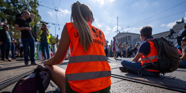 Klimaaktivistin sitzt bei einer Demo auf der Straße