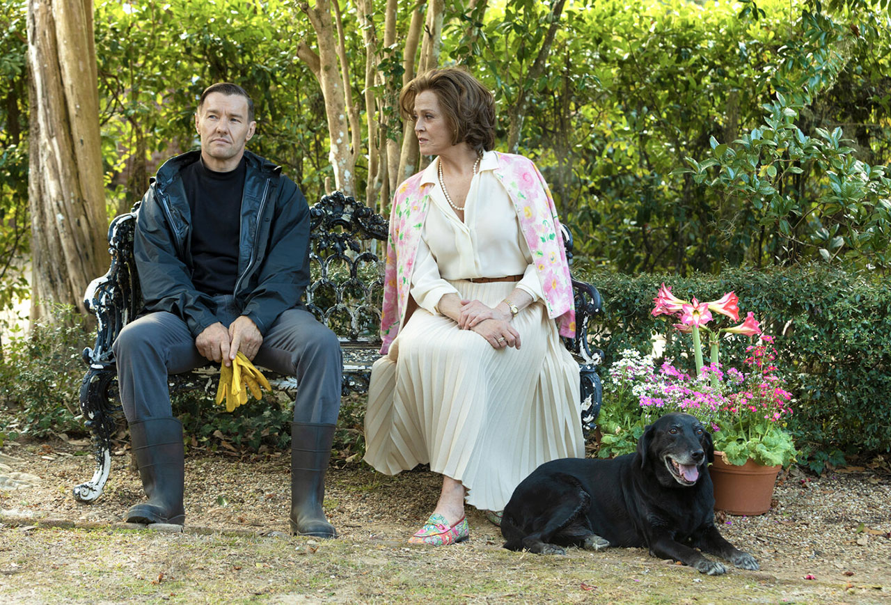 Szene aus Master Gardener: Mann und Frau sitzen nebeneinander auf einer Parkbank