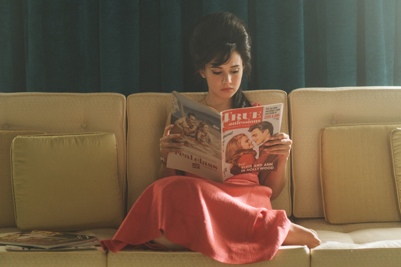 Eine Frau sitzt auf einem Sofa und liest eine Zeitschrift