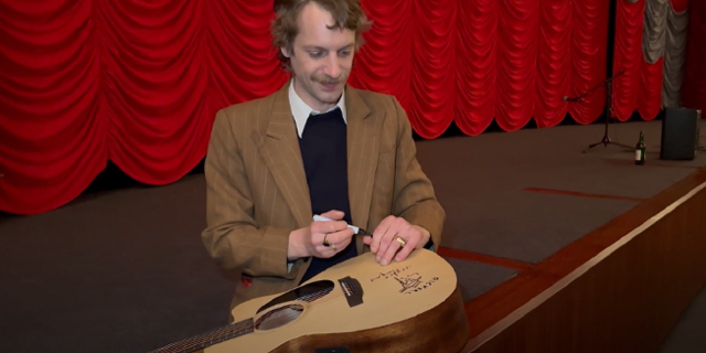 Voodoo Jürgens mit signierter Gitarre