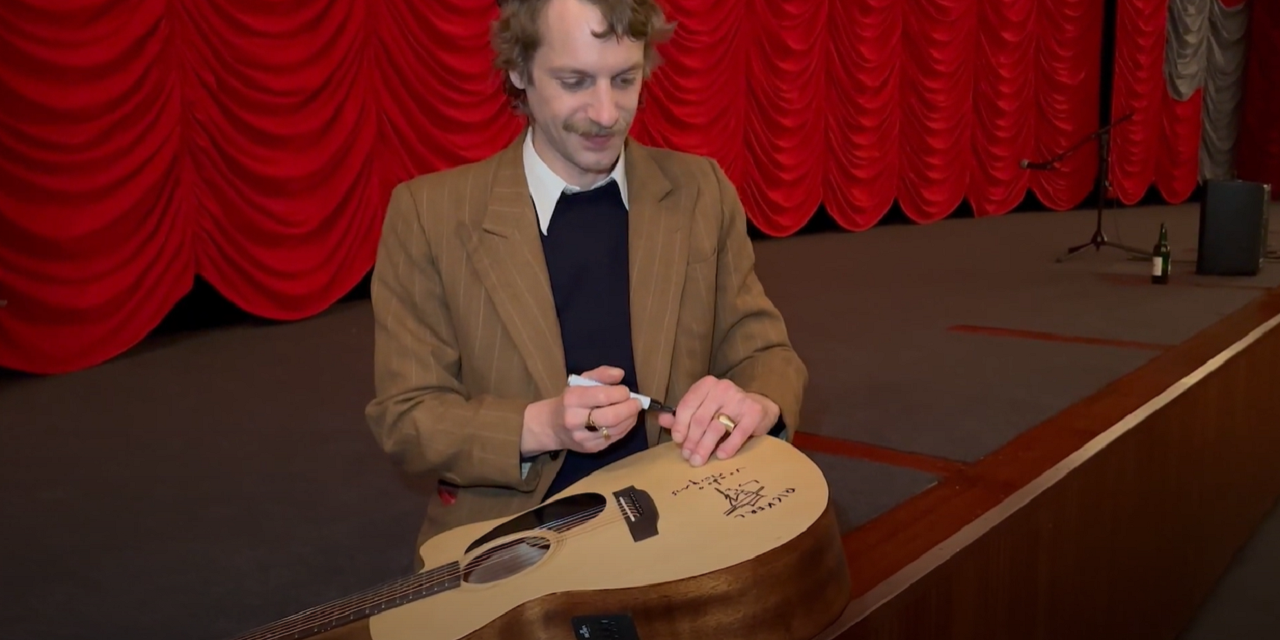 Voodoo Jürgens mit signierter Gitarre