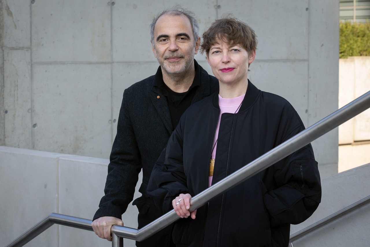 Dominik Kamalzadeh und Claudia Slanar stehen auf einer Treppe im Freien.