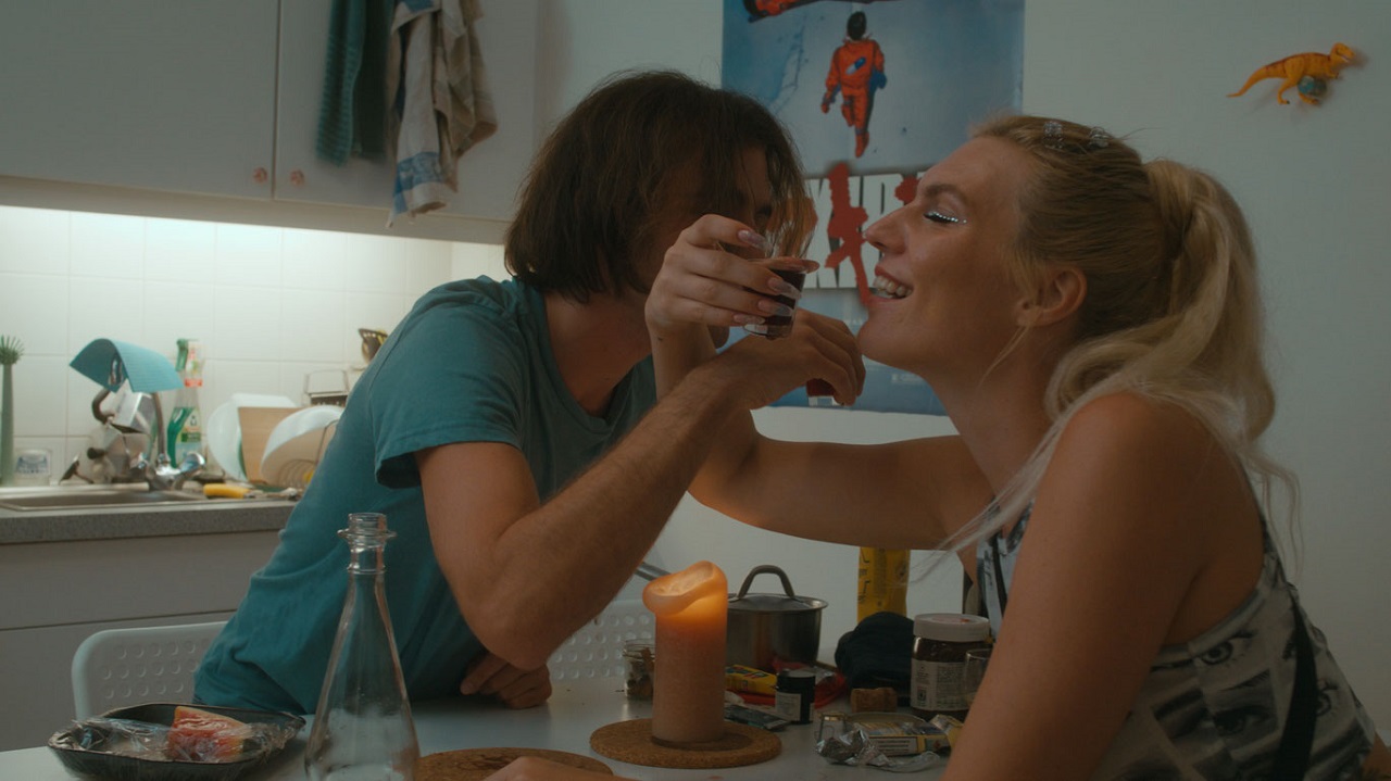 Zwei Menschen umarmen einander und haben Alkohol vor sich, Szene aus Elena Wolffs "Asche".