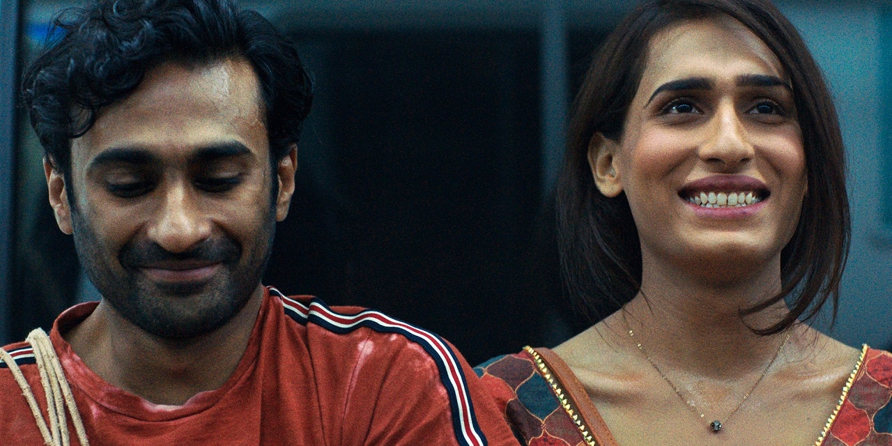 Ali Junejo und Alina Khan im Spielfilm "Joyland": Sie sitzen nebeneinander und lächeln verliebt.