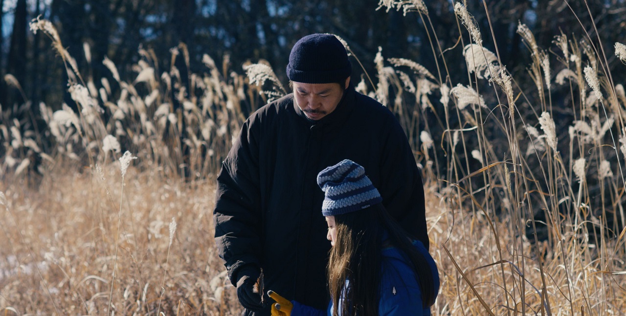Ein Vater und seine Tochter stehen auf einer Waldlidchtung. Szene aus "Evil does not exist".