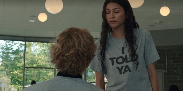 Screenshot aus "Challengers": Eine junge Frau steht vor einem jungen Mann und spricht mit ihm. Sie trägt ein Shirt mit der Aufschrift "I told ya"
